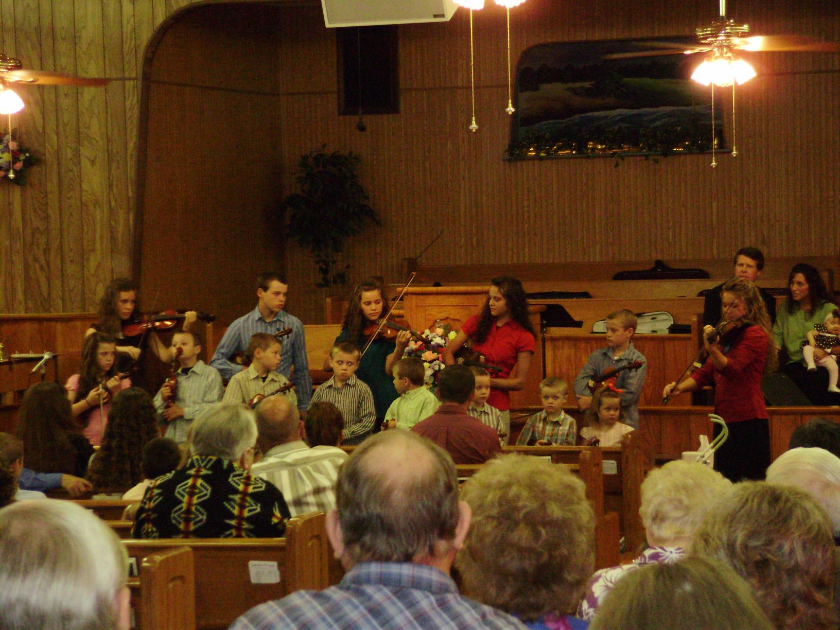 Duggar Children play their violins for the congregation